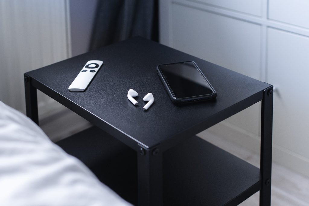 cell phone on table next to bed